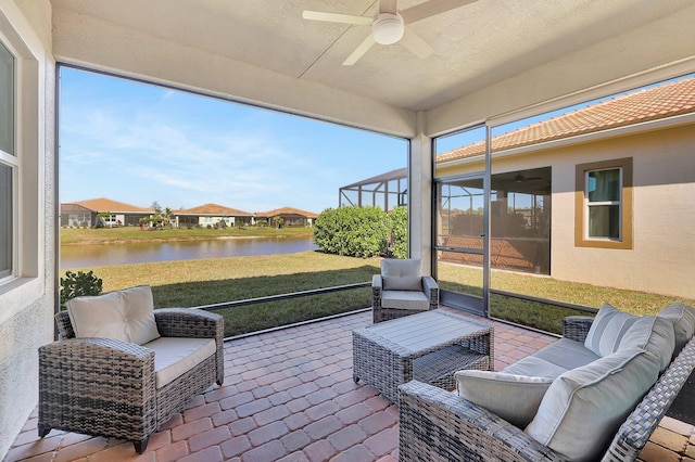 sunroom / solarium featuring a water view and ceiling fan