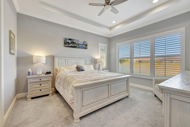 carpeted bedroom featuring ornamental molding, ceiling fan, and a tray ceiling