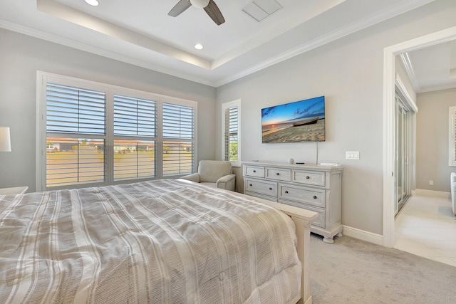 carpeted bedroom featuring ornamental molding, ceiling fan, and a tray ceiling