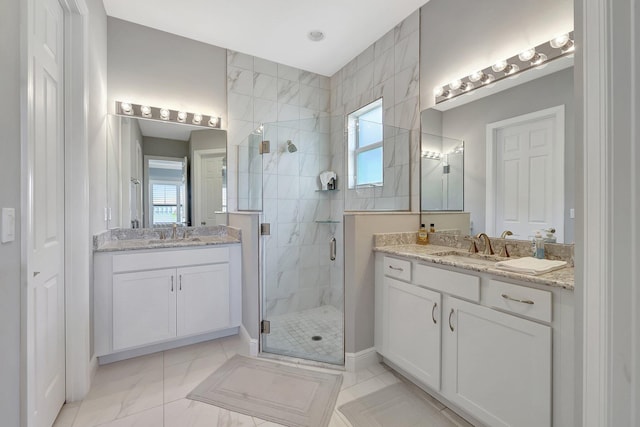 bathroom with a shower with door, vanity, and a healthy amount of sunlight