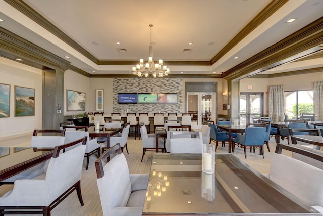 dining room featuring ornamental molding, a raised ceiling, a chandelier, and french doors