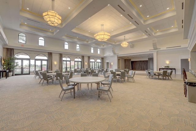 carpeted dining room featuring coffered ceiling, a towering ceiling, ornamental molding, and french doors