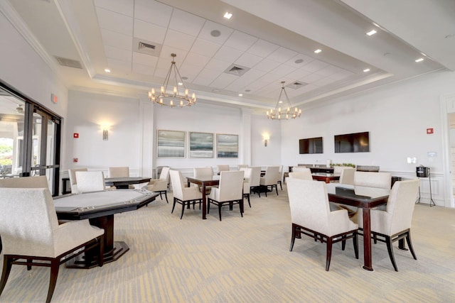 dining space featuring a raised ceiling, crown molding, a high ceiling, and light carpet