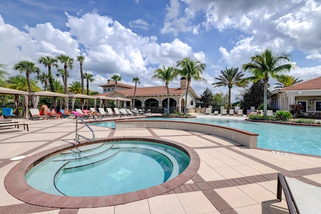 view of pool with a hot tub and a patio area