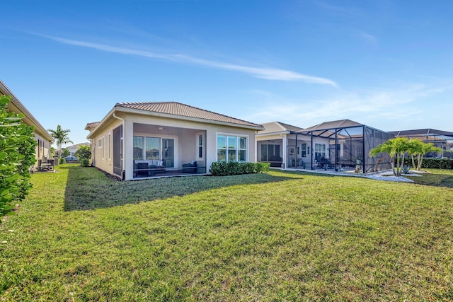 rear view of property with a lanai and a lawn