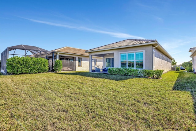 rear view of house with a yard and a lanai