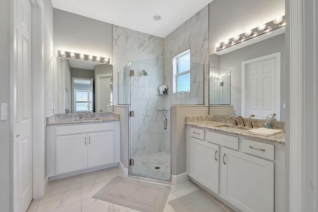 bathroom featuring a healthy amount of sunlight, a shower with shower door, and vanity