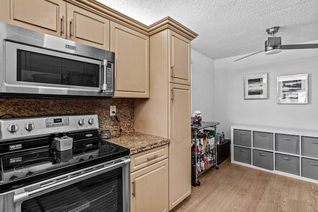 kitchen featuring stainless steel appliances, light brown cabinets, ceiling fan, tasteful backsplash, and light hardwood / wood-style flooring