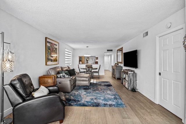 living room featuring a textured ceiling and light hardwood / wood-style flooring