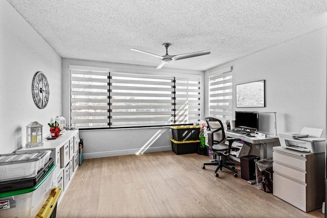 home office with a textured ceiling, ceiling fan, light hardwood / wood-style floors, and plenty of natural light