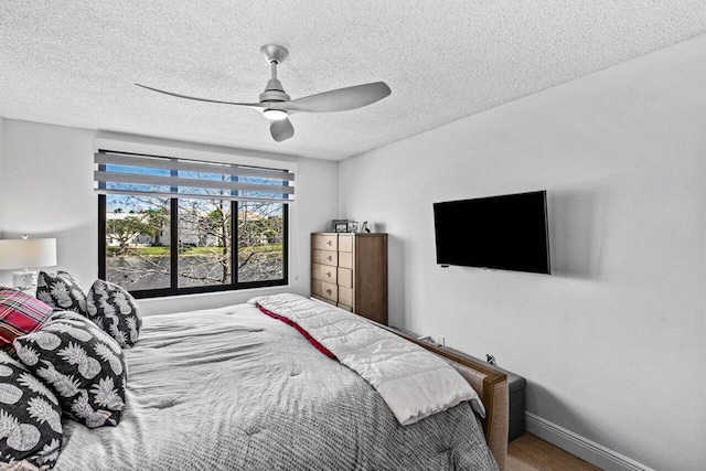 bedroom with a textured ceiling, ceiling fan, and wood-type flooring