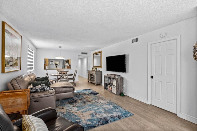 living room featuring a textured ceiling and light wood-type flooring