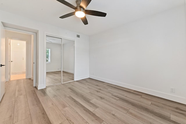 unfurnished bedroom featuring light wood-type flooring, ceiling fan, and a closet