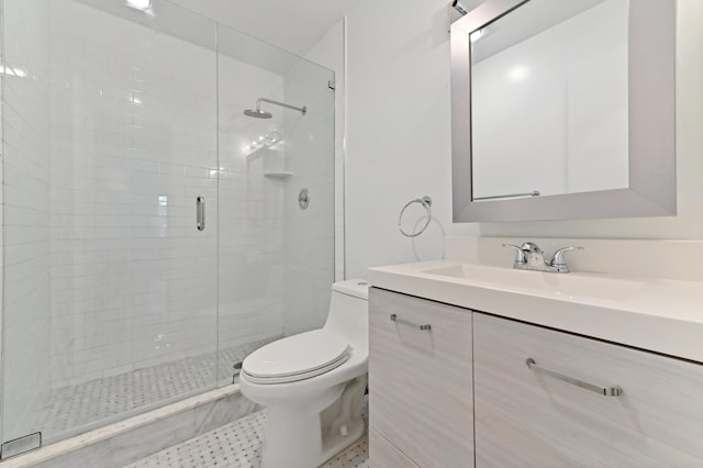 bathroom featuring a shower with door, toilet, and vanity