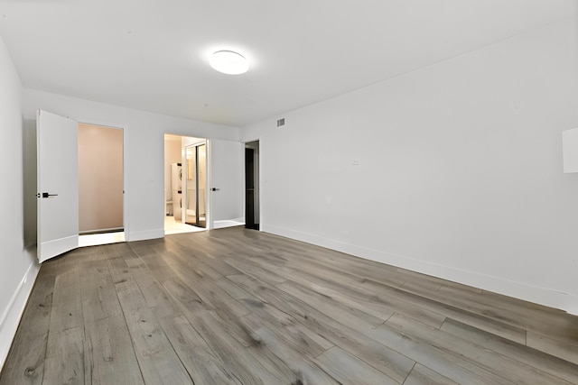 interior space with ensuite bathroom and light hardwood / wood-style flooring