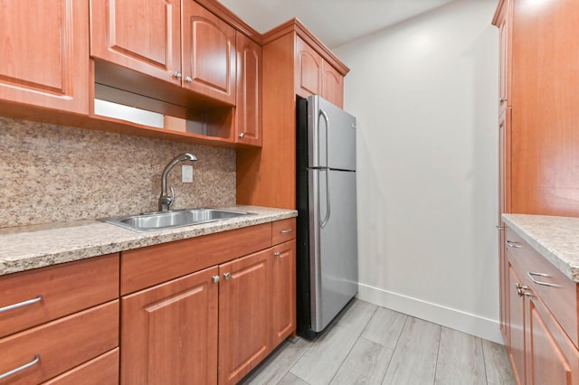 kitchen featuring decorative backsplash, stainless steel fridge, and sink