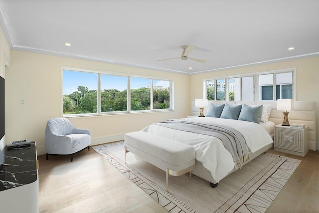 bedroom featuring ceiling fan, ornamental molding, and light wood-type flooring