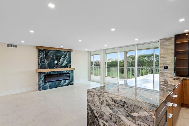 living room featuring a high end fireplace and floor to ceiling windows