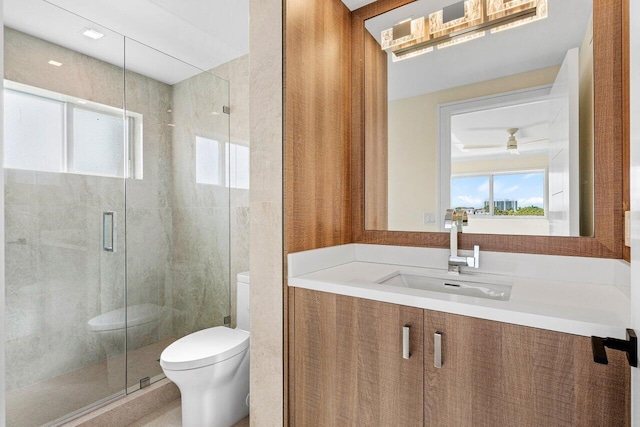 bathroom featuring walk in shower, ceiling fan, vanity, and toilet