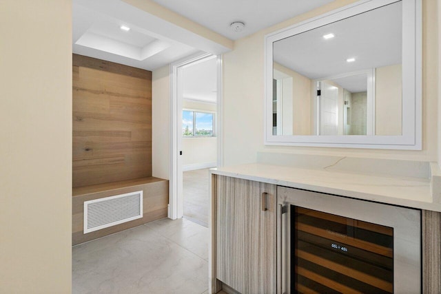 bathroom with tile patterned flooring, beverage cooler, and wooden walls