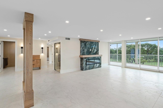 unfurnished living room featuring a fireplace, floor to ceiling windows, and a healthy amount of sunlight