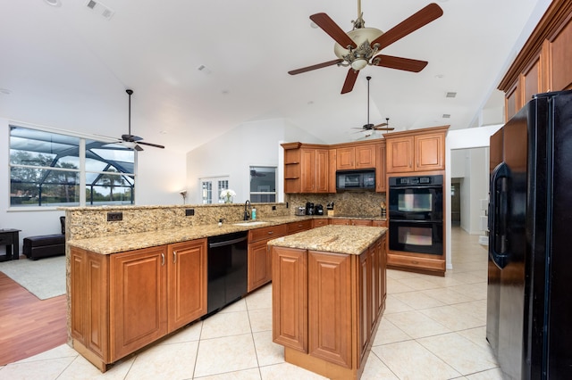 kitchen featuring sink, kitchen peninsula, lofted ceiling, a kitchen island, and black appliances