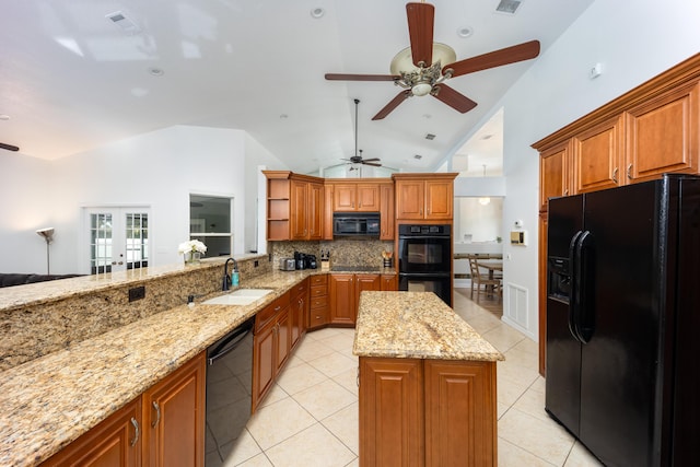 kitchen featuring backsplash, light stone counters, sink, black appliances, and a kitchen island