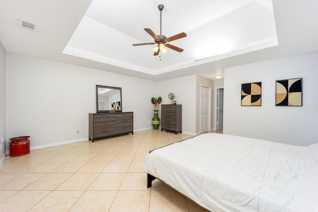 tiled bedroom with a tray ceiling and ceiling fan