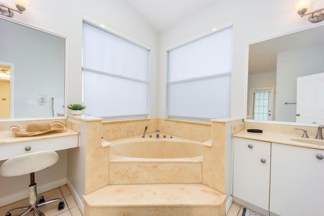 bathroom featuring a washtub, vanity, tile patterned floors, and lofted ceiling