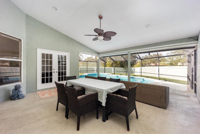 sunroom with ceiling fan, lofted ceiling, and french doors