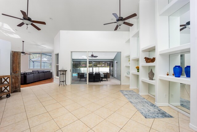 tiled living room featuring built in shelves and high vaulted ceiling