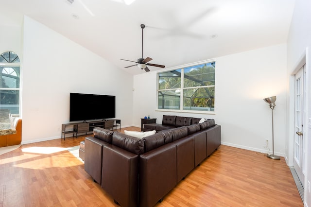 living room with ceiling fan, light hardwood / wood-style floors, and lofted ceiling