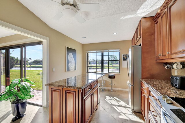 living room featuring ceiling fan, light tile patterned floors, a textured ceiling, and high vaulted ceiling