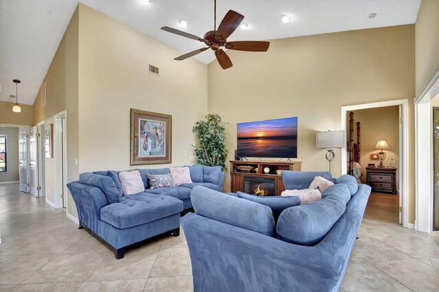 living room with ceiling fan, light tile patterned flooring, and high vaulted ceiling