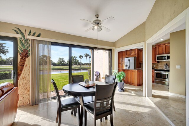 dining space with ceiling fan, plenty of natural light, lofted ceiling, and light tile patterned floors