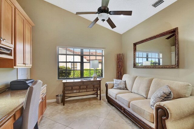 tiled living room with ceiling fan and lofted ceiling