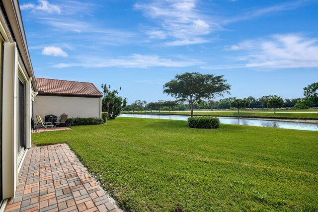 view of yard with a water view and a patio