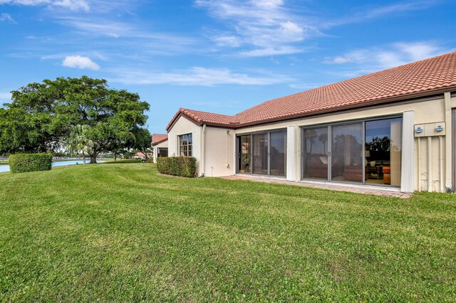 rear view of house featuring a lawn