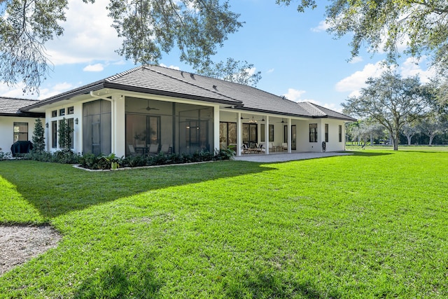 back of property featuring ceiling fan, a yard, a patio area, and a sunroom