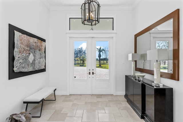 entryway with french doors, a chandelier, and ornamental molding