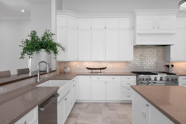 kitchen with sink, white cabinets, stainless steel appliances, and dark stone countertops