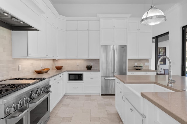 kitchen featuring appliances with stainless steel finishes, decorative light fixtures, custom range hood, white cabinets, and sink