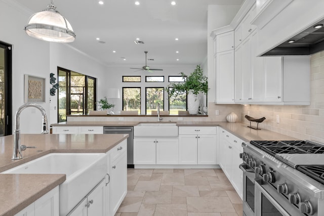 kitchen featuring ceiling fan, appliances with stainless steel finishes, custom range hood, and sink