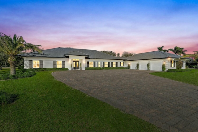 prairie-style house featuring a yard and a garage