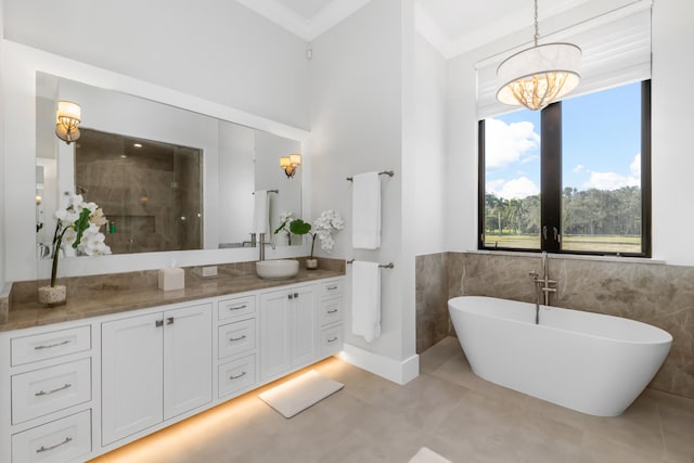 bathroom with a washtub, tile walls, vanity, and an inviting chandelier