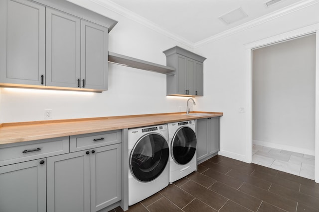 laundry area with sink, crown molding, washing machine and clothes dryer, and cabinets