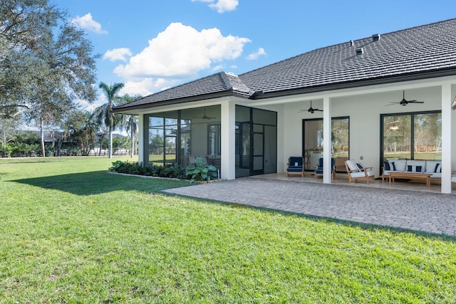 rear view of house with a sunroom, a patio area, ceiling fan, a lawn, and an outdoor hangout area