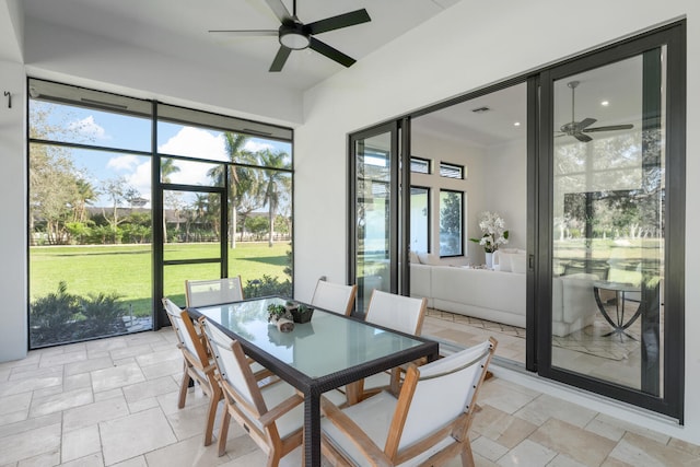 sunroom with a healthy amount of sunlight and ceiling fan