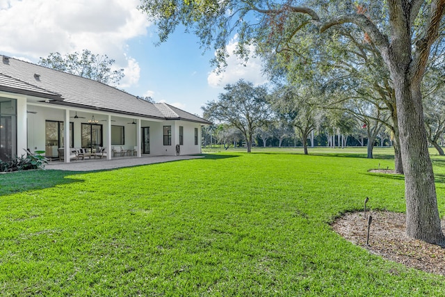 view of yard featuring ceiling fan and a patio