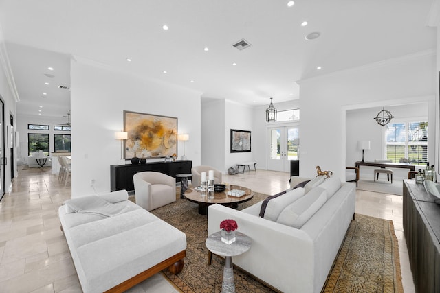 living room with french doors, crown molding, and a notable chandelier